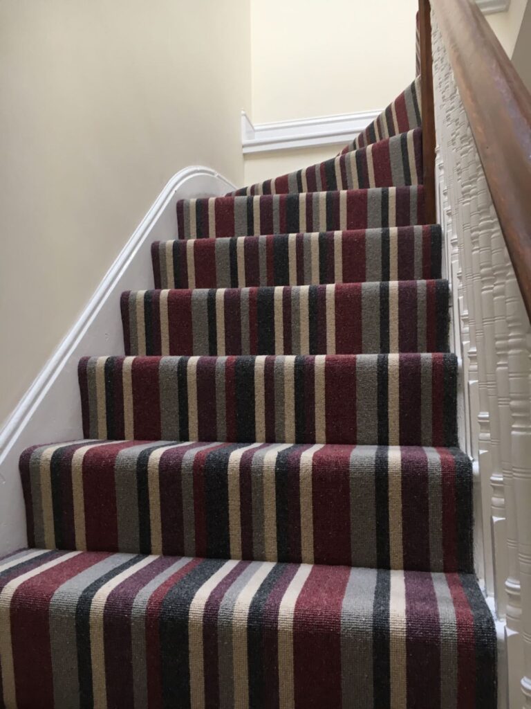 Striped carpet fitted on a flight of stairs by professional local carpet fitters Parsons Flooring