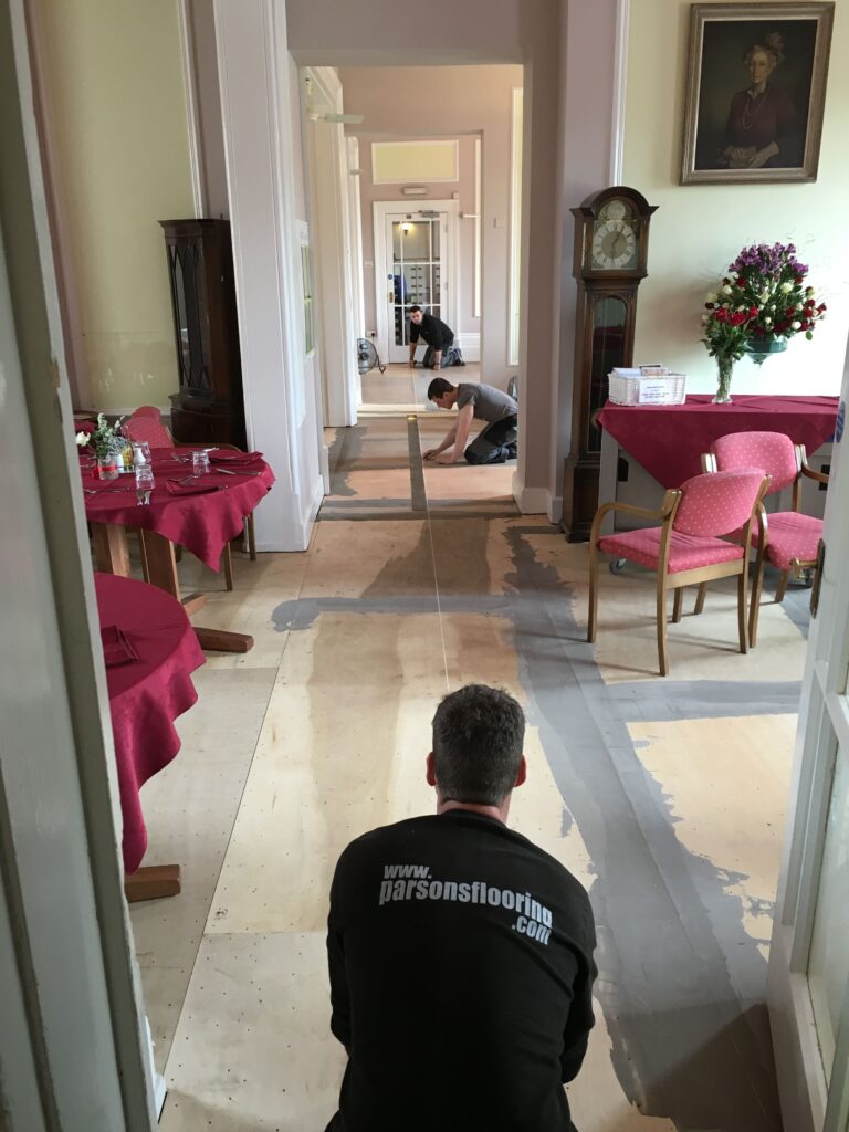 Parsons flooring team laying flooring for a customer